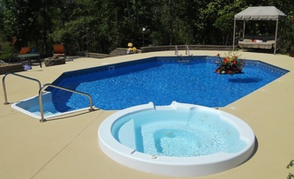 A finished Cochran vinyl-lined pool with an attached spa